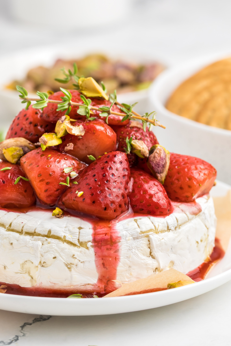 Up close photo of baked brie with roasted strawberries on top